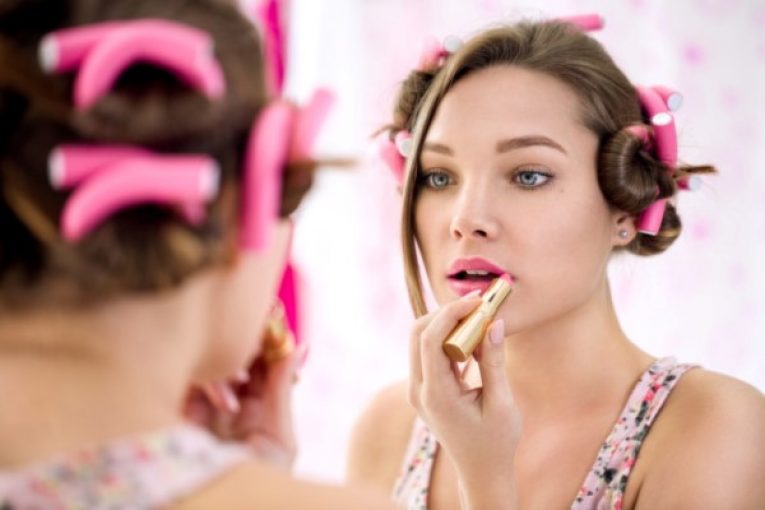young girl applying lipstick and doing her make up ready